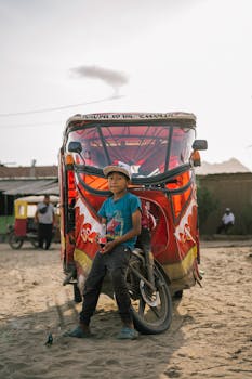 Boy sitting in front of a colorful rickshaw in Trujillo, Peru, capturing local transportation scene.