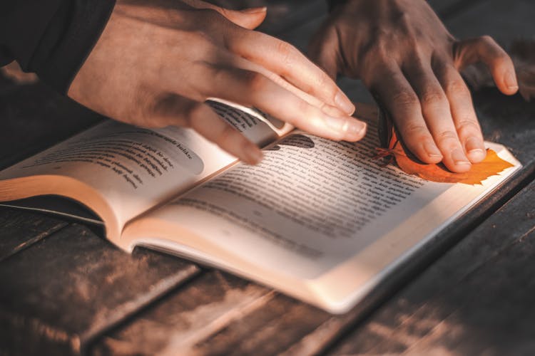 Persons Hands On An Open Book