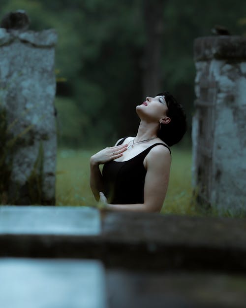 Woman in Black Dress among Walls