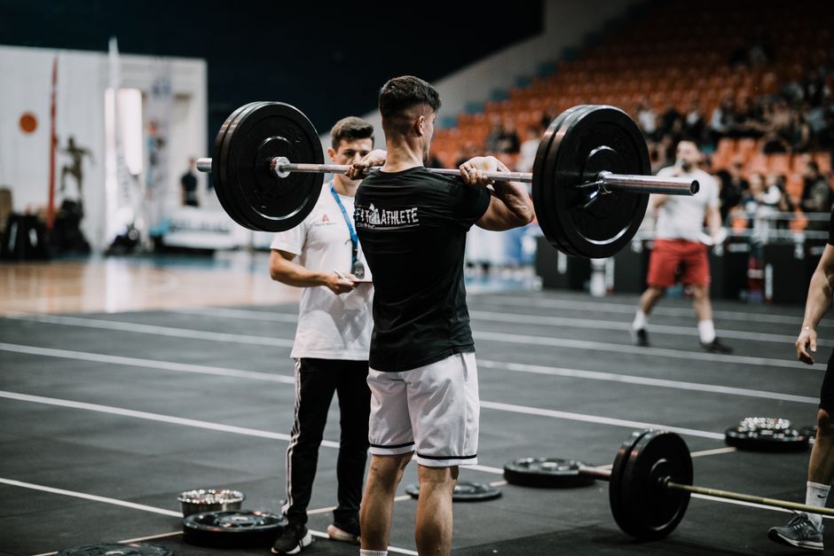 Athlete performing a hang power clean with explosive hip extension - Lineman workout program Athlete performing a hang power clean with explosive hip extension - Lineman workout program