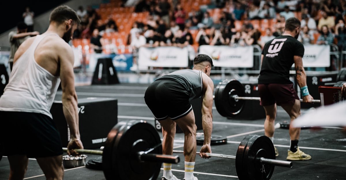 A group of athletes performing deadlifts during a competitive weightlifting event indoors. - Evidence evidence guide for Ashwagandha: Cortisol, Testosterone & How Long It Takes to Work