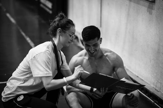 Trainer and client discussing fitness plan in gym. Black and white photo capturing a coaching session.