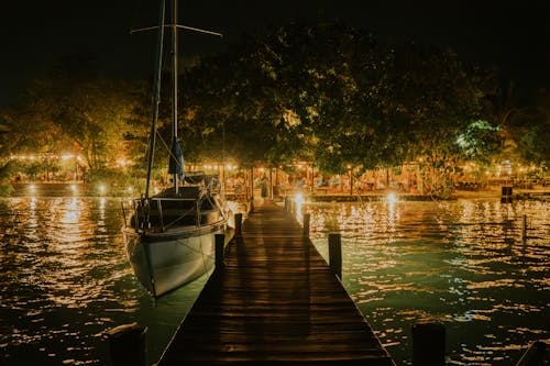 Boat Moored by a Pier in an Illuminated Harbor