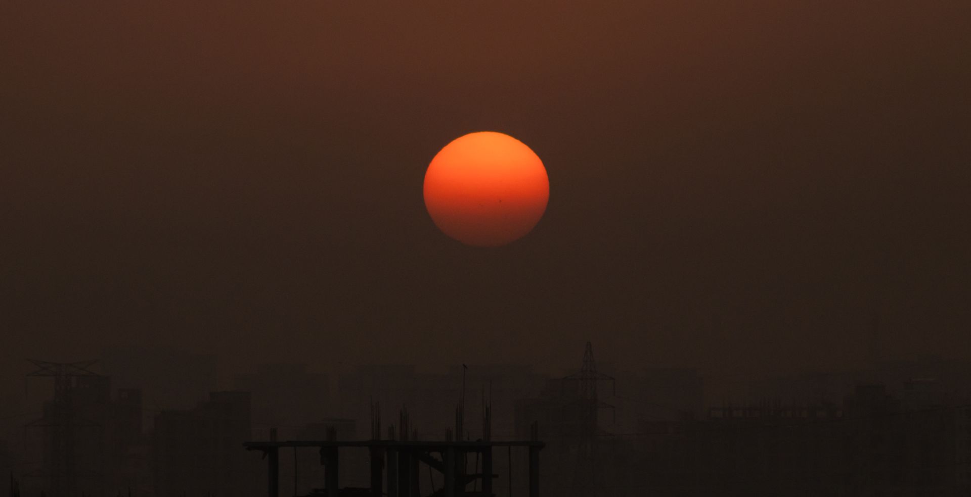 La silhouette d'une ville sous un ciel brumeux pendant la canicule