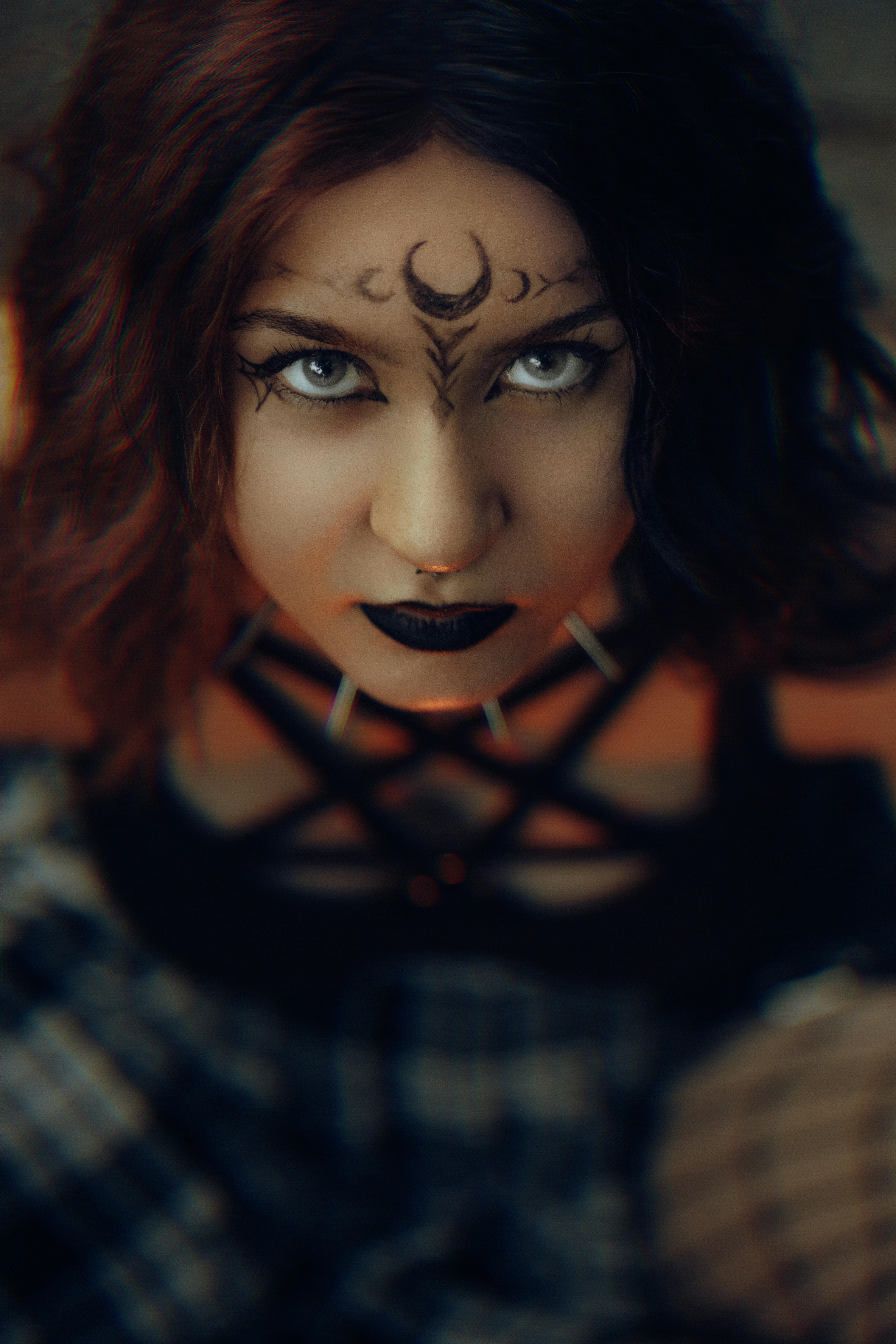 Captivating portrait of a woman with gothic makeup and moon forehead design.
