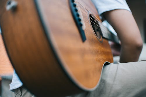 Selective Focus Photo of Man Holding Guitar