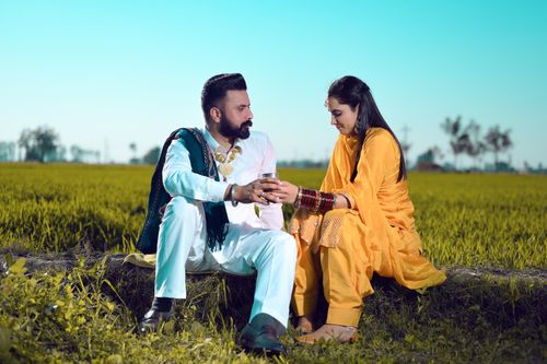 Free A happy Indian couple in traditional attire enjoying a moment in a lush green field. Stock Photo