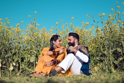 Free Happy couple enjoying a sunny day in a mustard field, embodying love and joy. Stock Photo