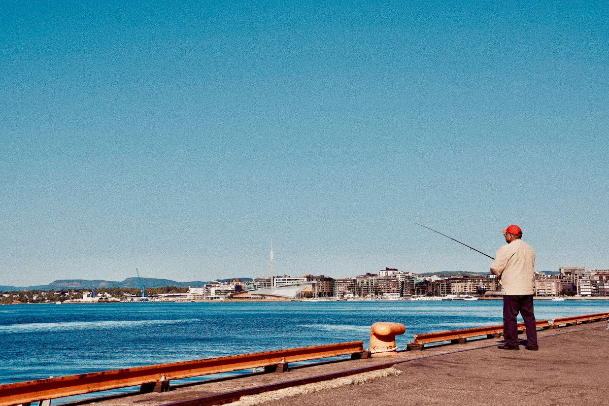 a man in a business suit shaking hands with a fisherman on a sunny pier
