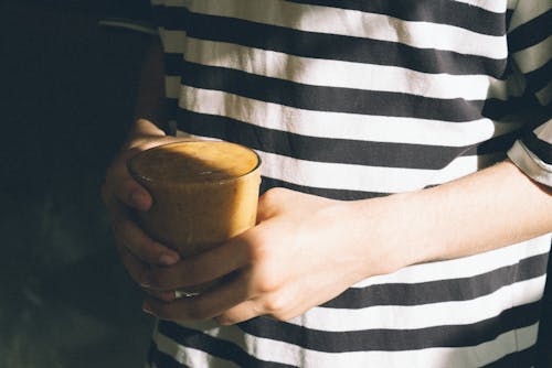 Hands Holding Glass of Coffee