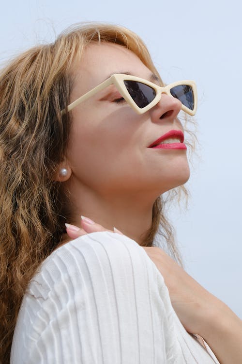 Young Woman in Sunglasses Standing Outdoors and Smiling 