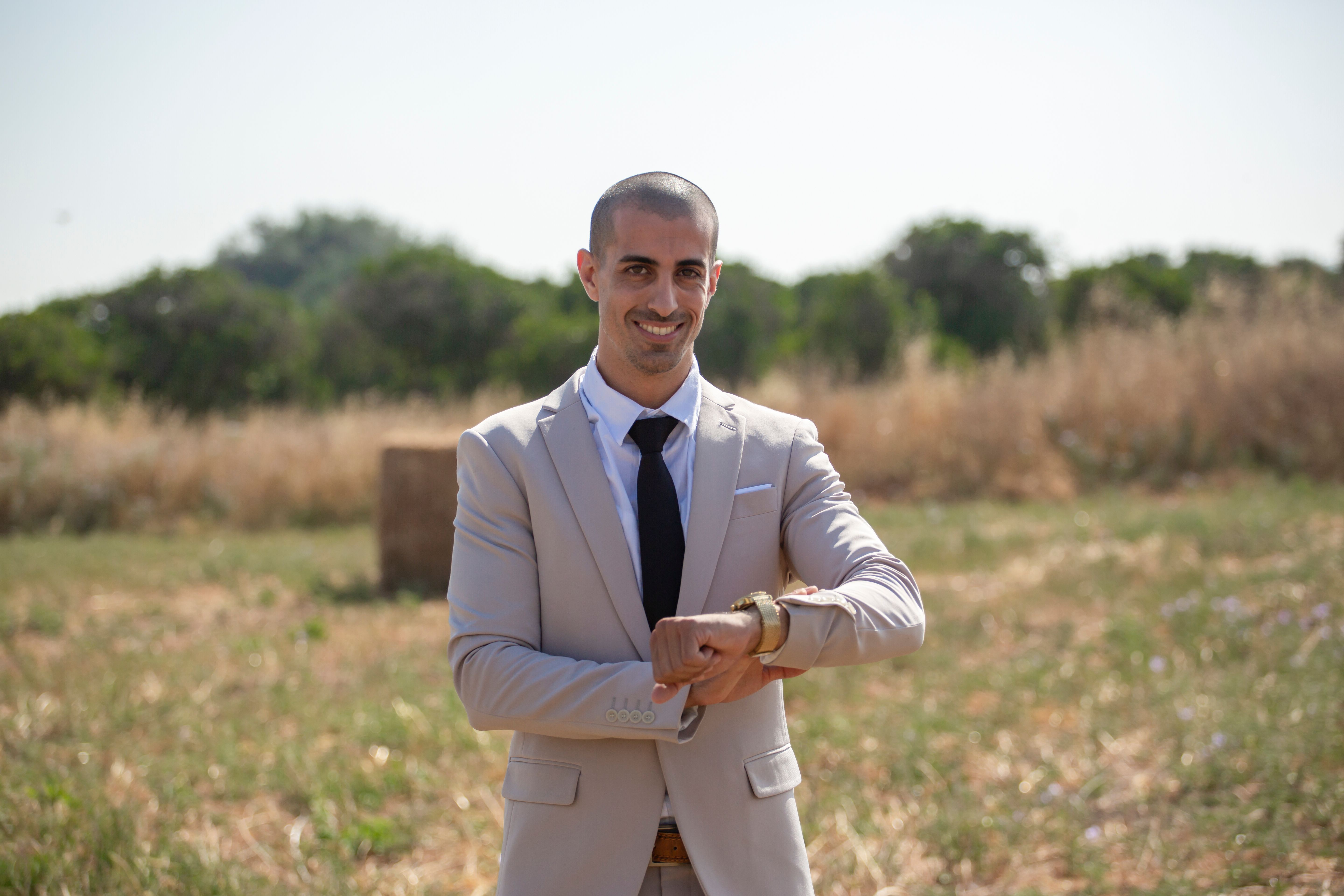A man in a suit and tie standing in a field · Free Stock Photo