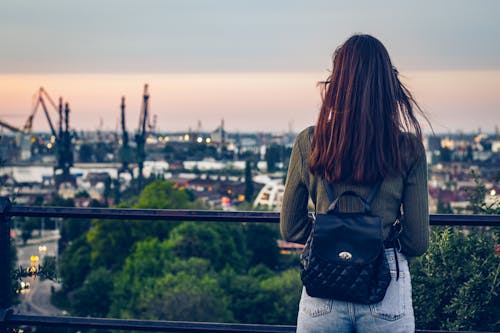 Standing woman looking at the industrial cityscape.