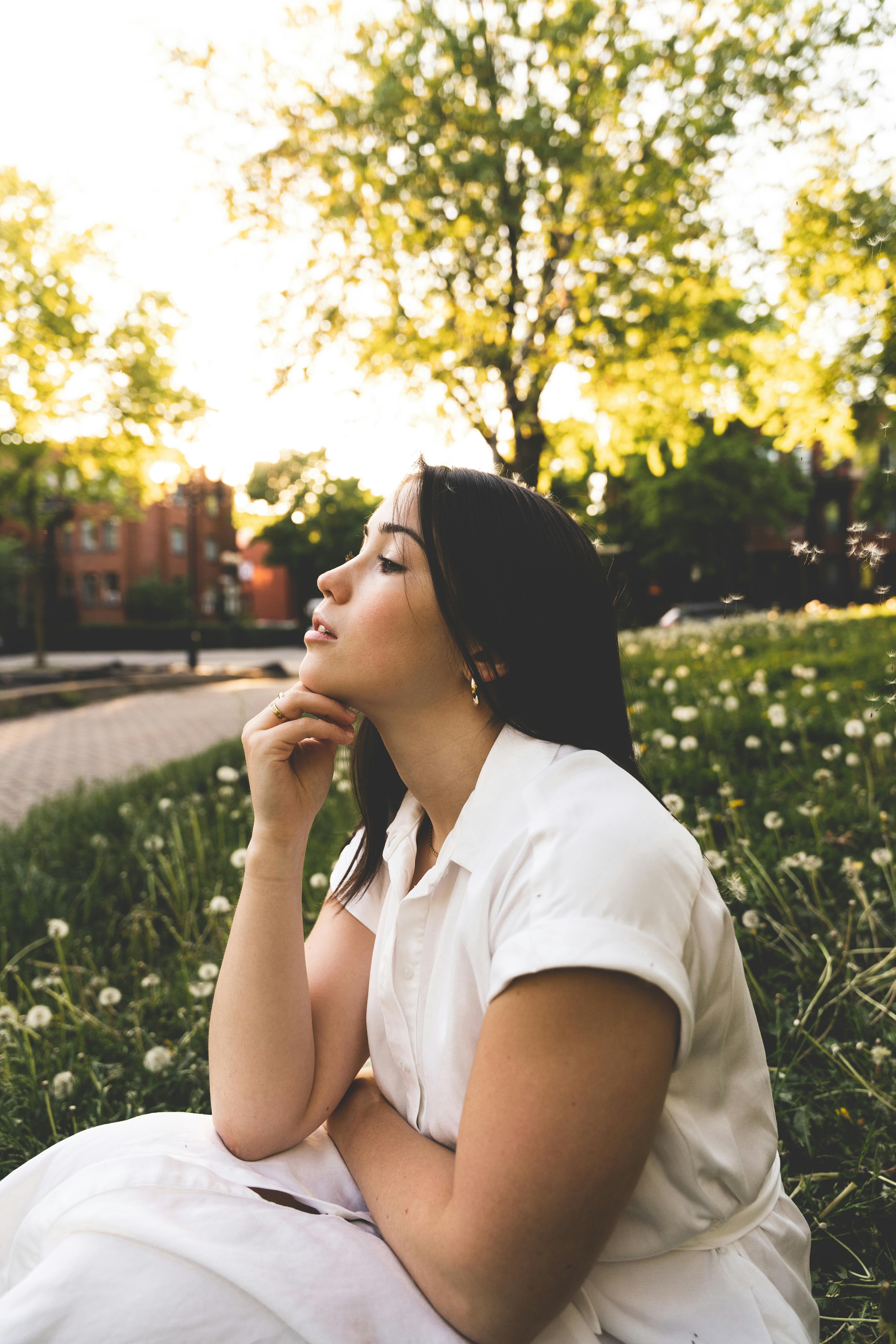 A woman sitting on the grass in a field