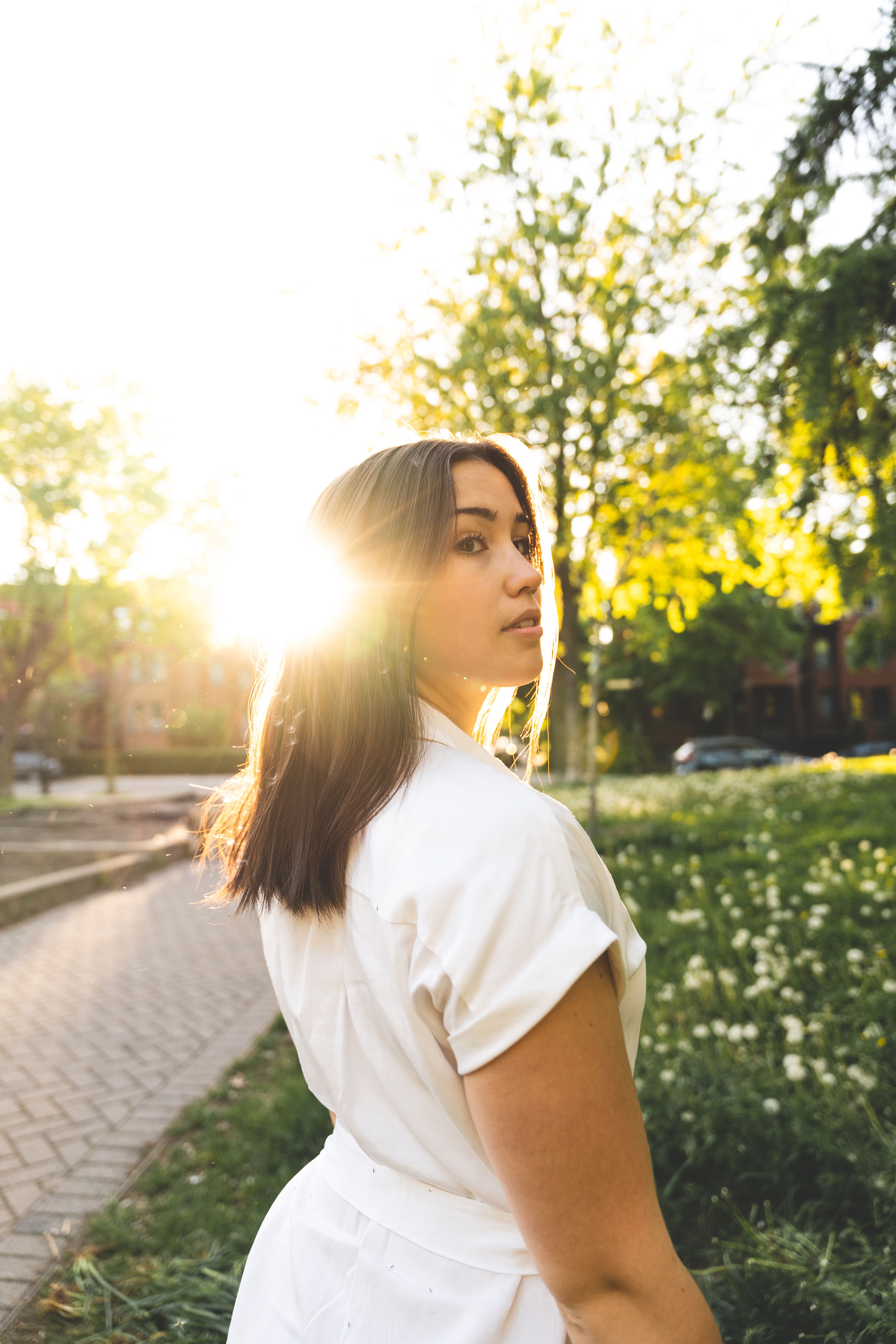 a woman in a white dress is standing in the sun