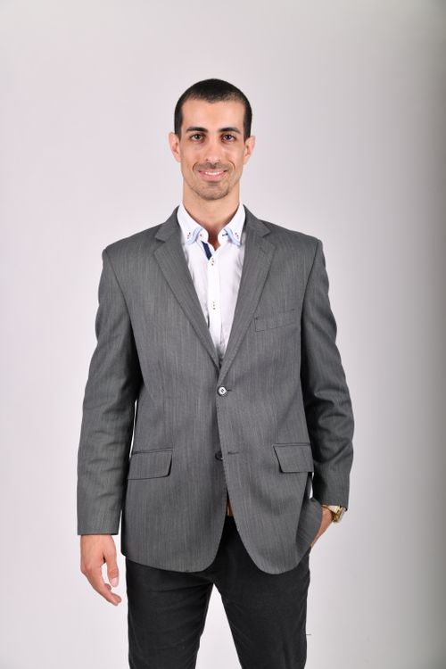 Free A well-dressed man in a gray jacket smiling in a studio shoot. Stock Photo