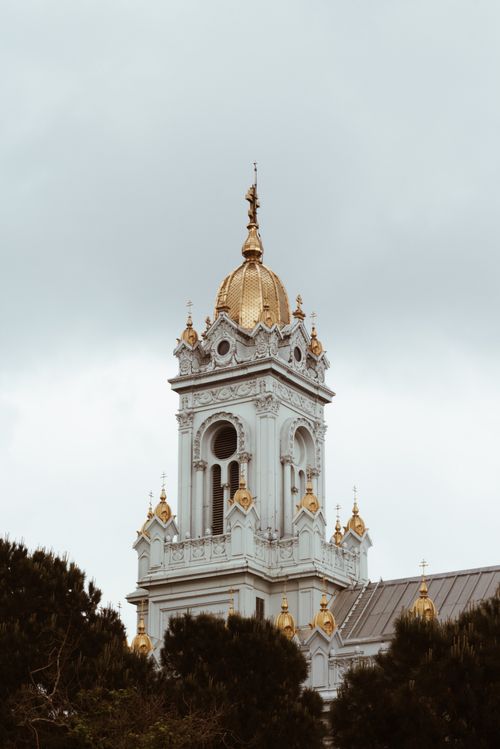 Free Ornate Orthodox church tower with golden dome against a cloudy sky. Stock Photo