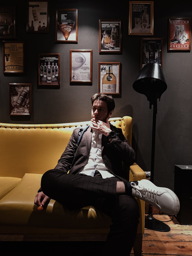 Man Sitting On Yellow Leather Sofa