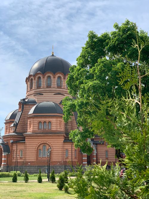 Free Stunning view of Narva's Orthodox cathedral surrounded by lush greenery on a sunny day. Stock Photo