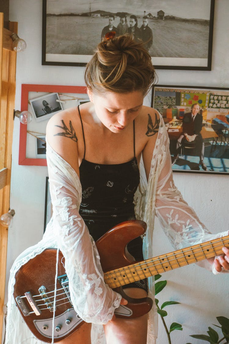 Young Woman In A Dress Holding An Electric Guitar