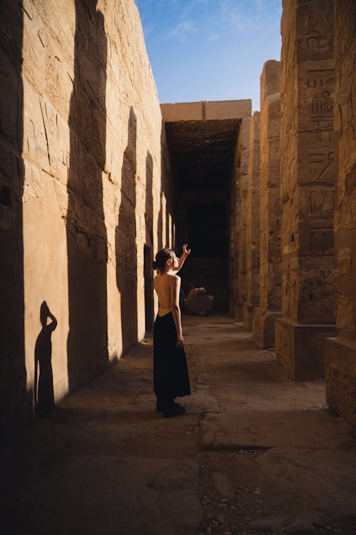 Woman Standing among Ancient Temple