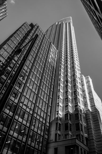 A dramatic low angle view of towering skyscrapers in monochrome.