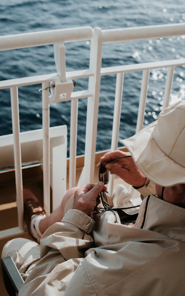 Man Sitting On Ship Deck