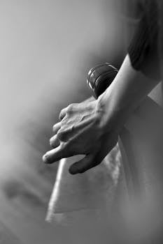 A detailed black and white close-up of a human hand showing texture and veins.
