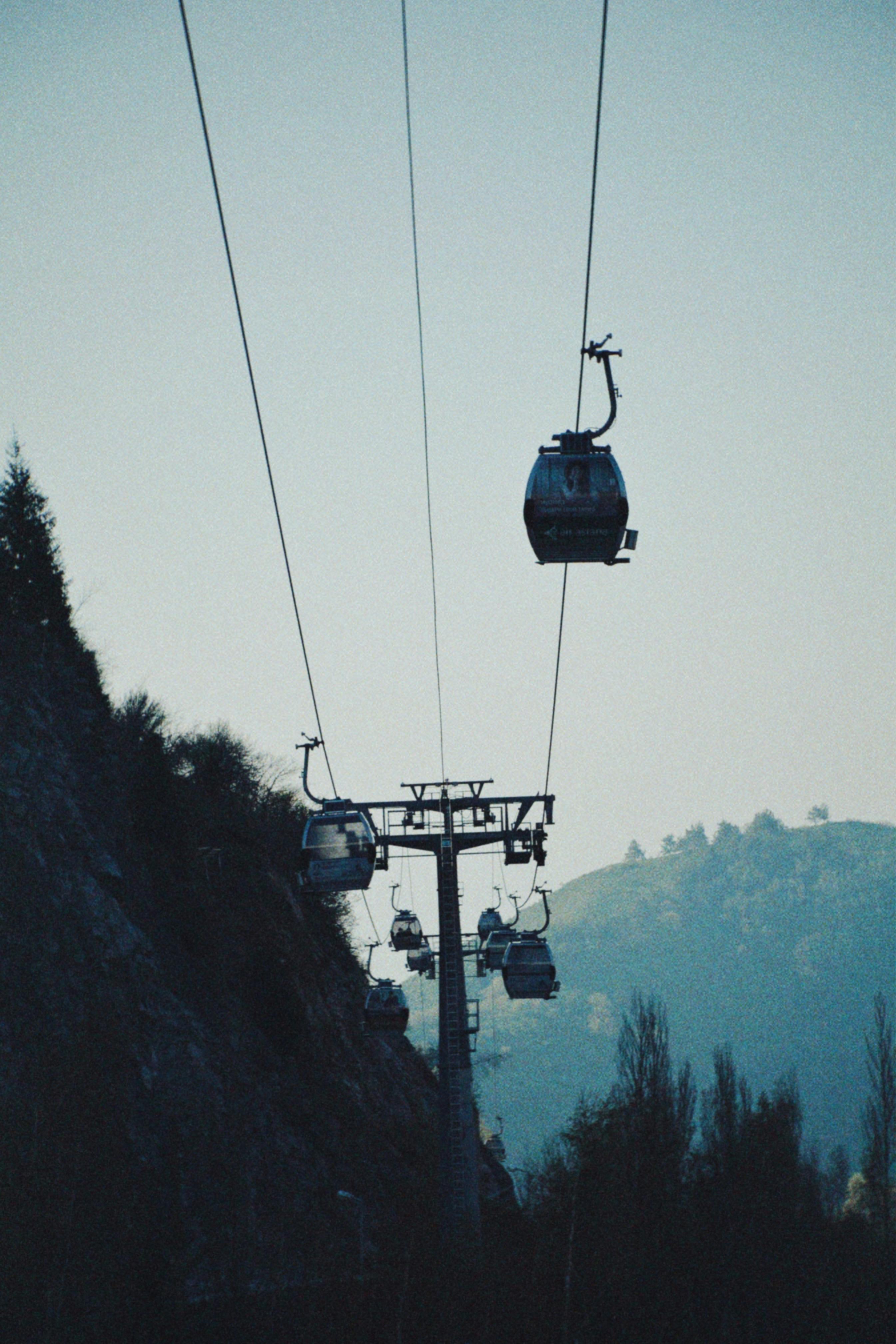 Cable cars traversing mountains in Almaty, Kazakhstan, offering breathtaking views.