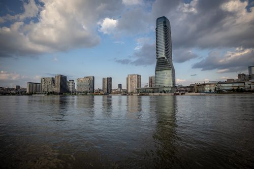 Free Skyline view of modern London skyscrapers reflected in the river under a cloudy sky. Stock Photo