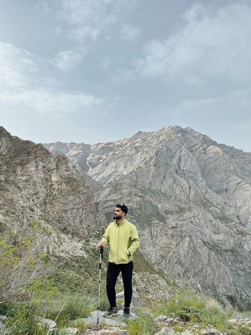 Free Man hiking with walking pole in Erbil Governorate, Iraq, showcasing stunning mountain landscapes. Stock Photo