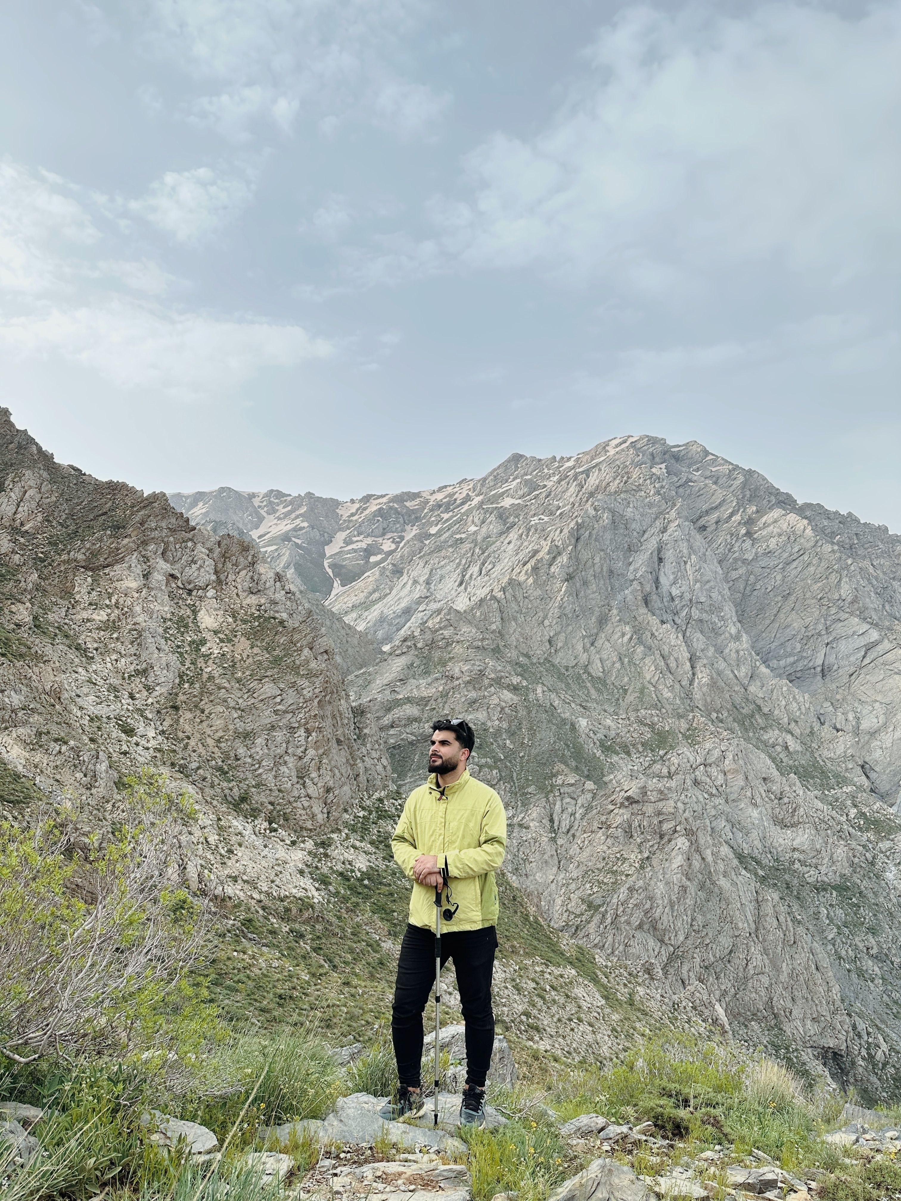 A man stands in a scenic mountain range in Erbil Governorate, Iraq, showcasing natural beauty.
