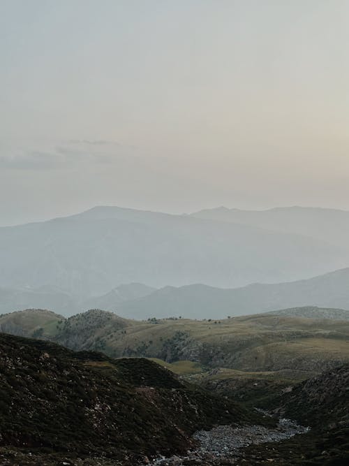 Foto profissional grátis de céu, colinas, garoa