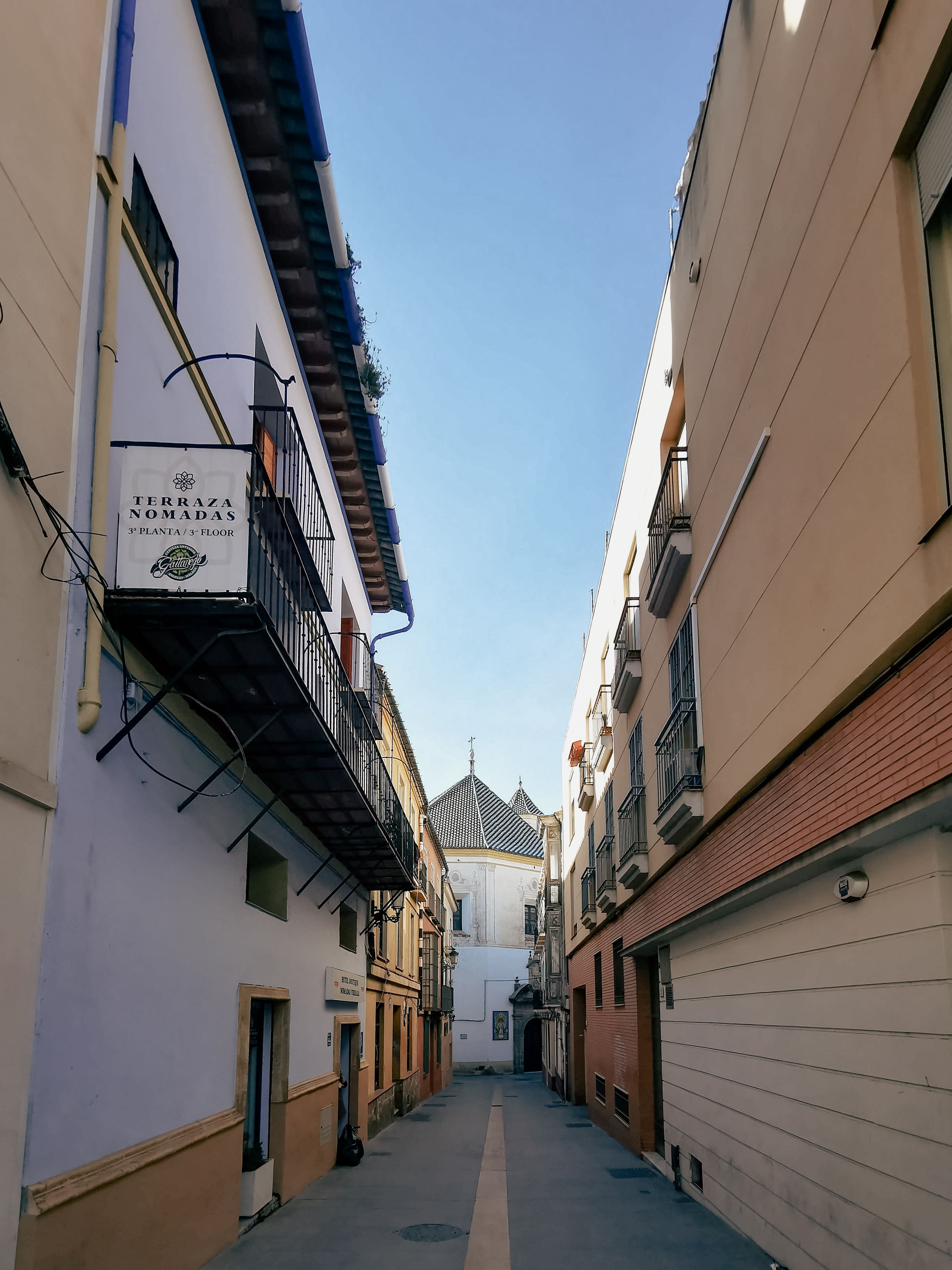 Explore a picturesque narrow street in Seville, showcasing urban life and architectural beauty.
