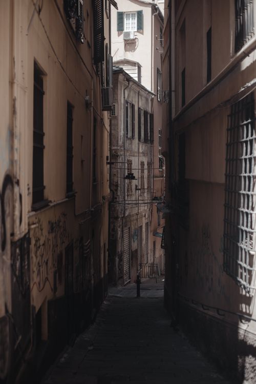 Free Moody view of a narrow alley in Genoa, showcasing Italian architecture and urban textures. Stock Photo