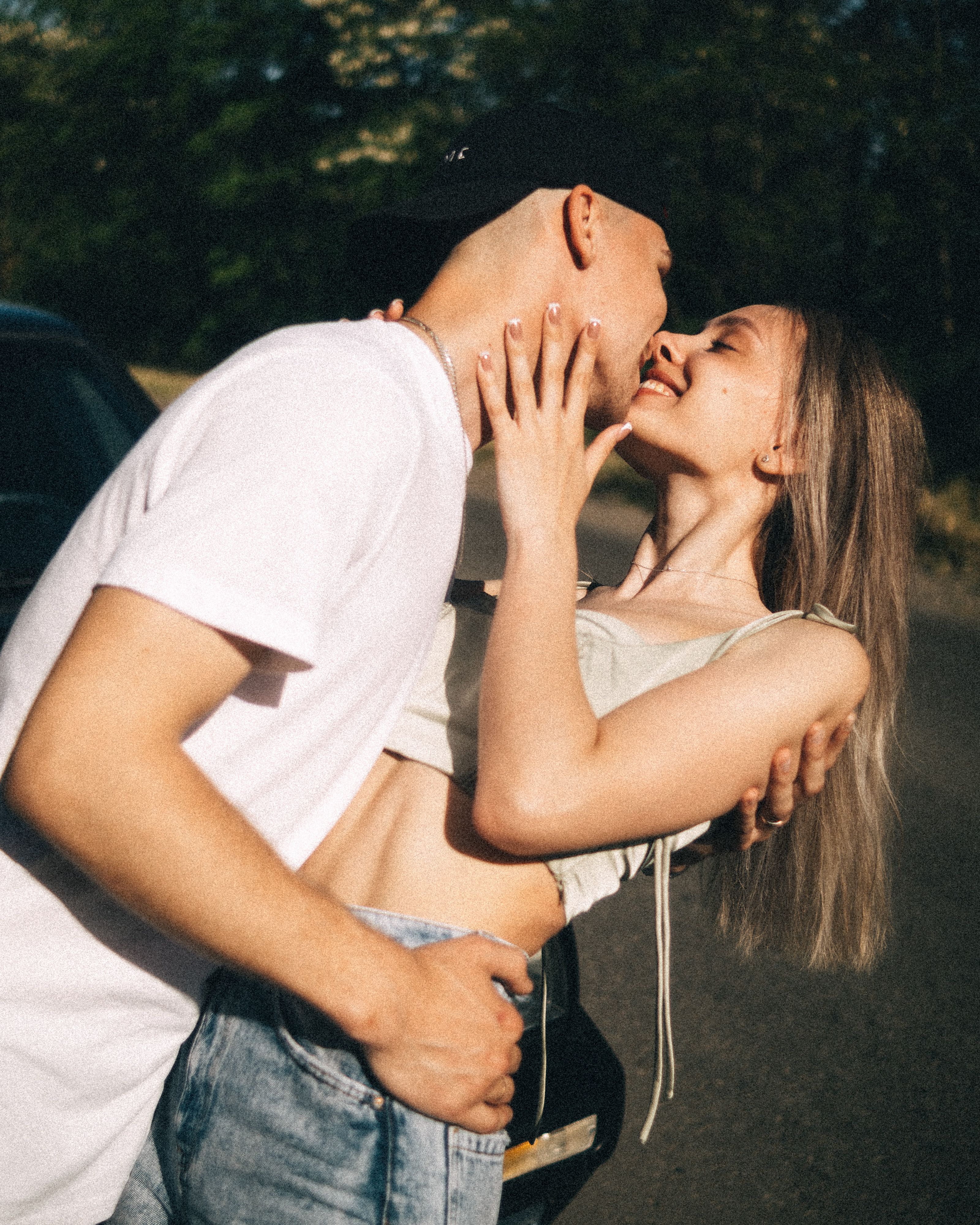Young couple enjoying a romantic moment together under sunlight outdoors in summer.