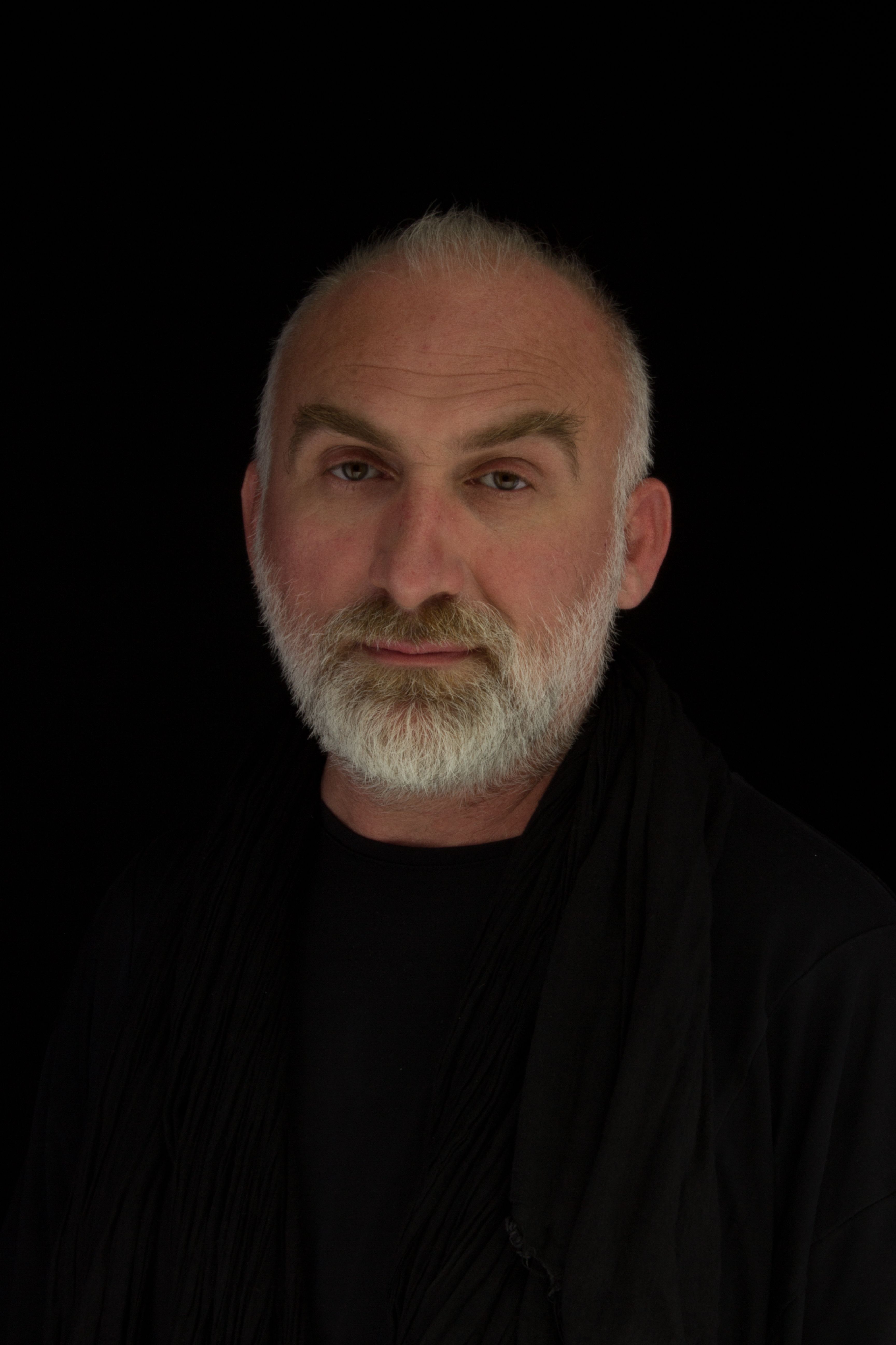 Studio portrait of a middle-aged man with gray beard and mustache