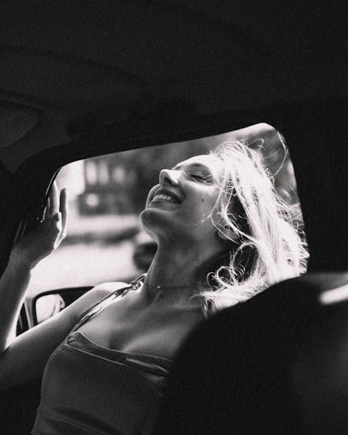 Smiling Woman Standing in Car