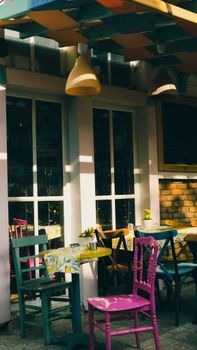 Vibrant sidewalk café setting in Istanbul with colorful chairs and tables.