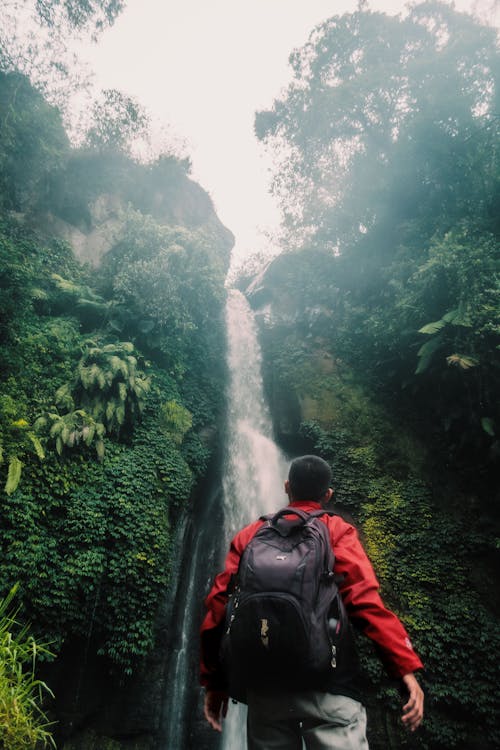 Mann, Der Schwarzen Rucksack Unter Wasserfall Trägt