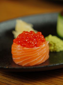 Close-up of gourmet salmon roe sushi artfully presented on a plate.