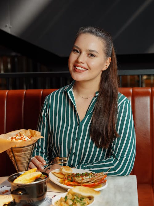 Smiling Woman Eating in Restaurant
