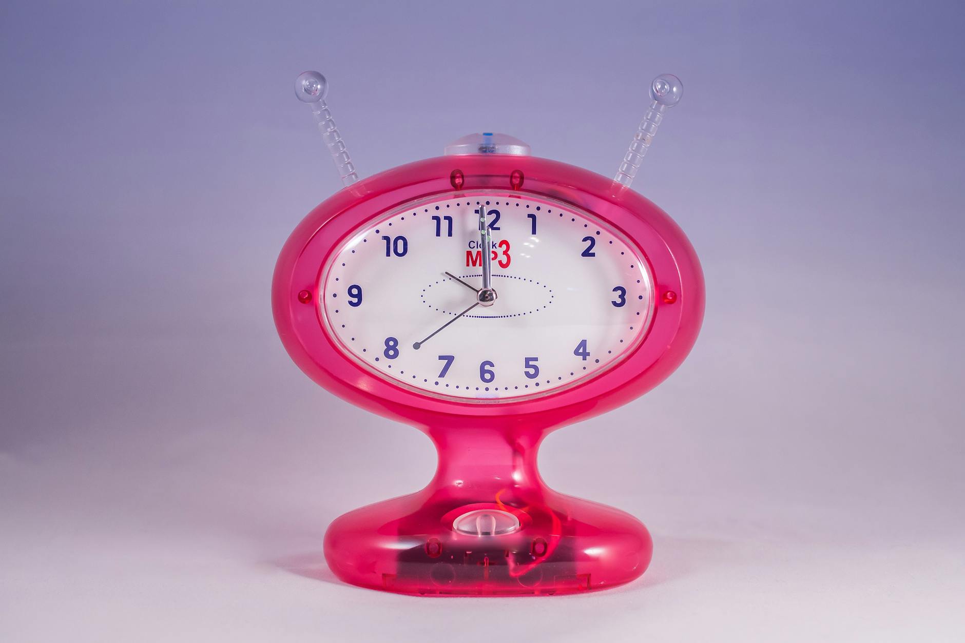 Pink and White Mp3 Analog Clock Displaying at 12:00