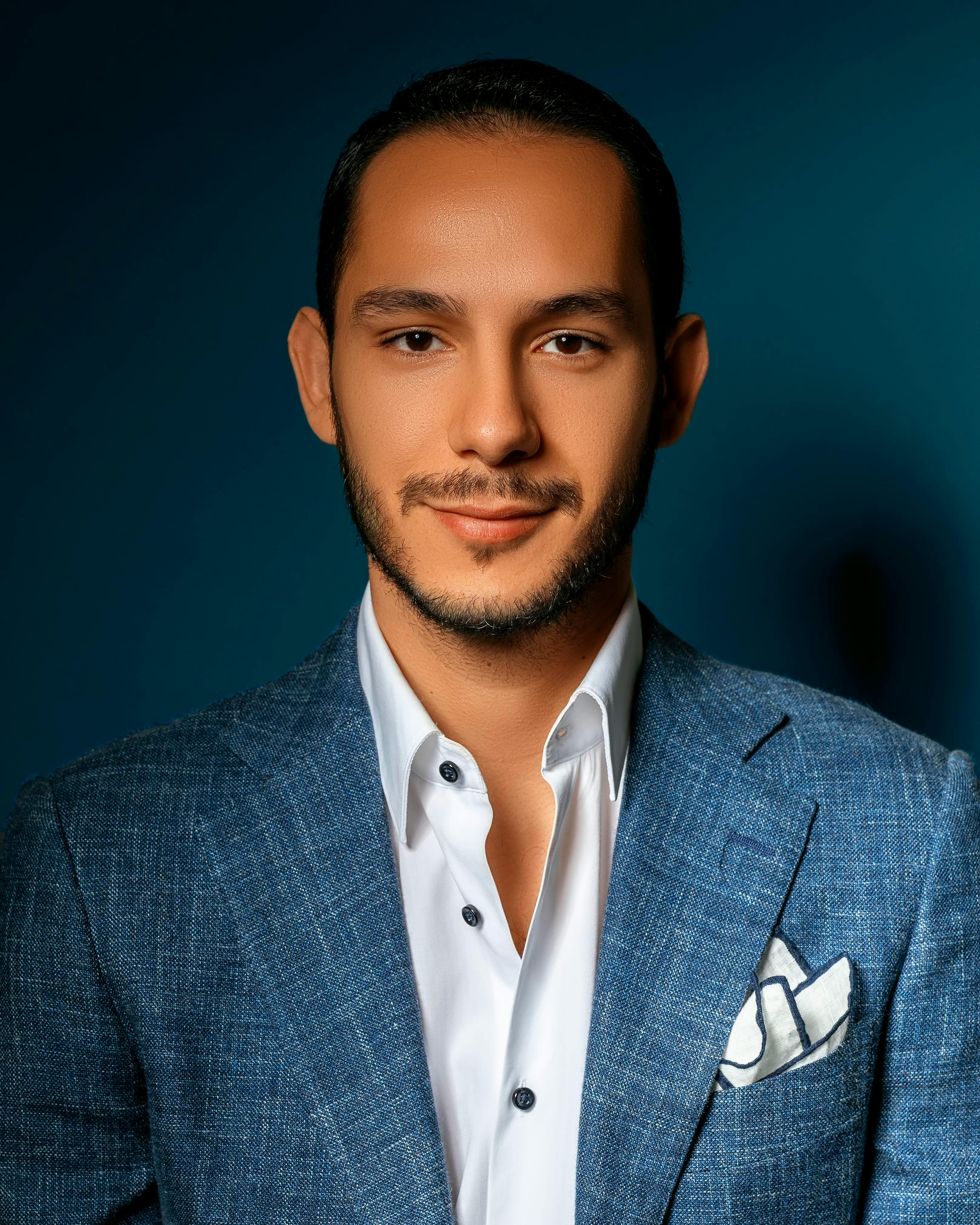Portrait of a confident man in a blue blazer, showcasing elegance and style.