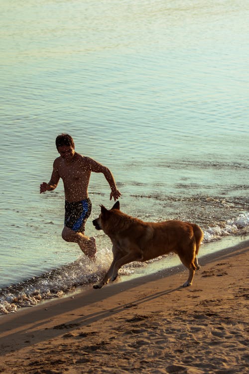 Man Running with Dog on Beach