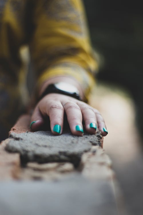 Woman's Hands Resting on Concrete Surface