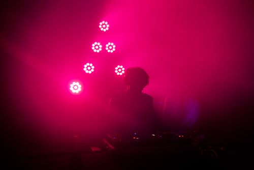 Free Silhouette of a DJ performing under intense red lighting, creating a moody atmosphere. Stock Photo