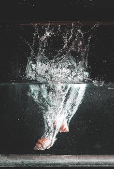 贝壳入水激起飞溅，水下可见气泡动态