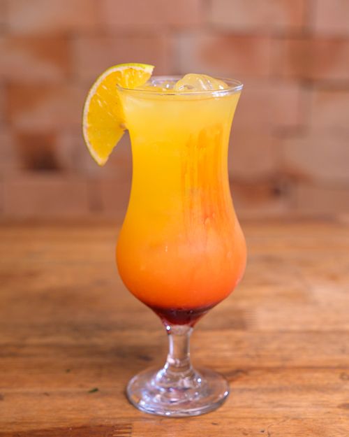 Free Vibrant citrus cocktail in a glass with orange slice garnish, perfect for summer refreshment. Stock Photo