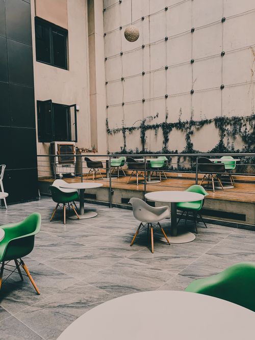 Free Stylish outdoor seating with green chairs and tables in a tranquil Nairobi setting. Stock Photo